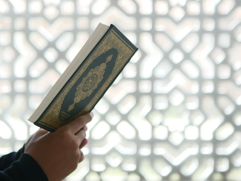 A Quran held by a reader